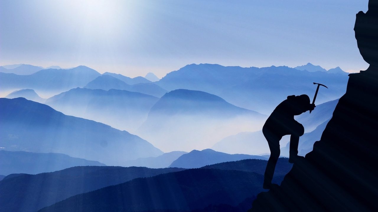 A climber ascending a mountain at sunrise, a metaphor for online reputation management and recovery